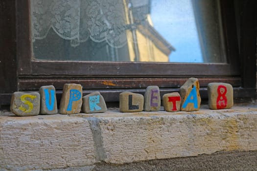 Colored stones by the window with the inscription Summer