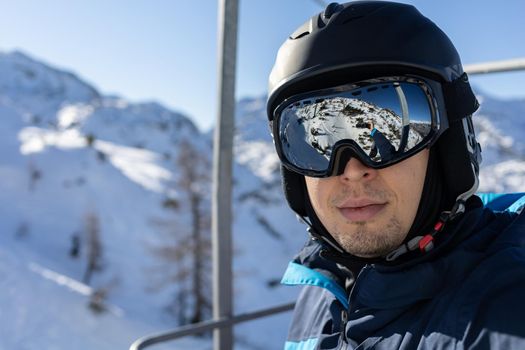 ski resort man portrait on chairlift in helmet and mask. High quality photo