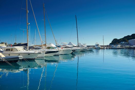 Monaco, Monte-Carlo, a lot o motor boats are moored in port at sunny day, mooring ropes go into the azure water, prows of motor boats in a row, boat railings . High quality photo