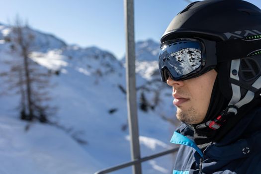 ski resort man portrait on chairlift in helmet and mask. High quality photo