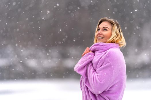 young woman rejoices in the first winter snow.