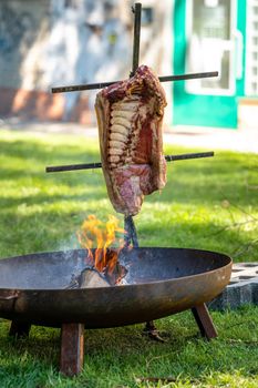 roasting meat on an open fire at a garden party.