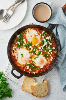 Shakshouka, eggs poached in sauce of tomatoes, olive oil, peppers, onion and garlic, Mediterranean cousine. Keto meal, FODMAP recipe, low carb. Top view, vertical