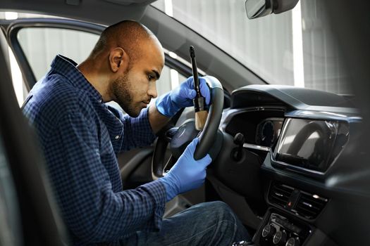 A man cleaning car interior, car detailing in Carwash service, close up