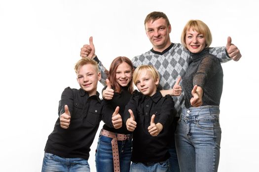 Portrait of an ordinary large family, everyone shows a thumbs up and joyfully looks into the frame a