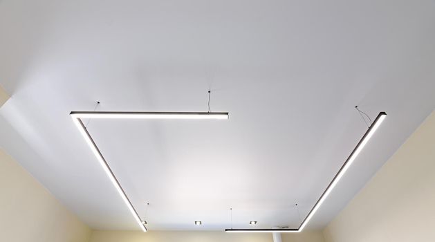 Modern white matte stretch ceiling with original fixtures a