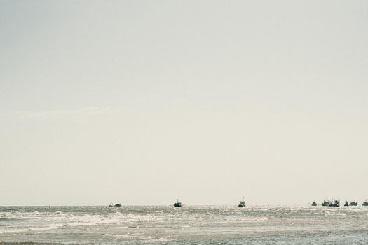 Pale blue gray tone seascape clear sky view. Real nature beauty background. boats sail skyline bay calm ripple sea. Fishing life style. trip leisure travel. Paradise tranquility serenity peace quiet.