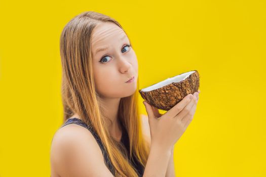 Young woman doing oil pulling over yellow background.