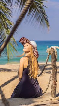 Vacation on tropical island. Woman in hat enjoying sea view from wooden bridge. VERTICAL FORMAT for Instagram mobile story or stories size. Mobile wallpaper