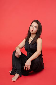 Full length portrait of gorgeous blonde lady with long hair wearing night out black overall and black heels, smiling at camera over grey background. Isolate. Studio portrait.