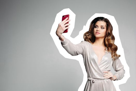 View of serious and pretty brunette girl with plump lips, wearing in silver dress, holding cell phone, smiling and taking photo. Attractive woman posing making self portrait. Comics effect.