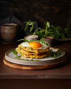 Homemade keto waffles with fried egg, flying arugula, mozzarella cheese. Levitation. Chaffles, ketogenic diet health food. Gluten free and carb free. Dark background