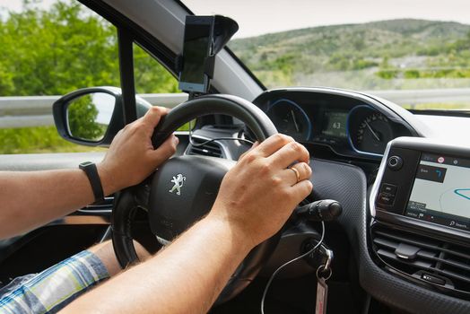 Split, Croatia - June 2021: Man driving Peugeot SUV car with hands on driving wheel. Car driving concept