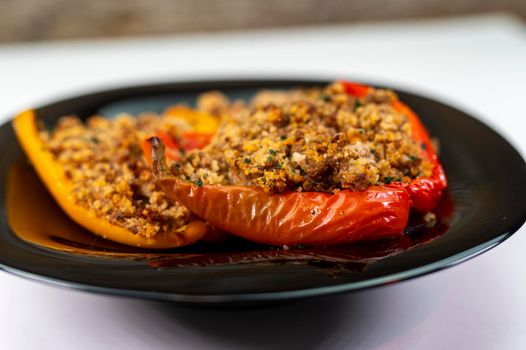 detail of a black dish with gratinated peppers