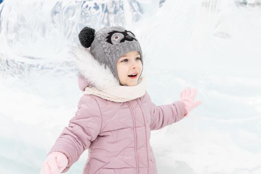 playful child girl happy in snow town on winter day