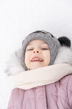 portrait of a happy little girl on a winter snowy day