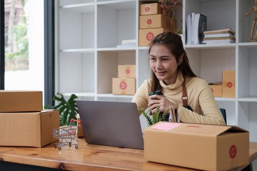 Small business aspiring entrepreneur, small and medium business freelance working in home office using computer, online marketing packaging box delivery, SME e-commerce telemarketing concept.