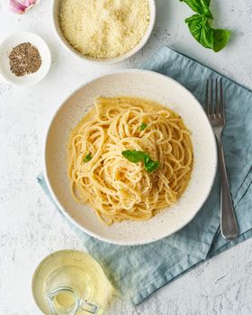 Cacio e pepe pasta. Spaghetti with parmesan cheese and pepper. Traditional italian cuisine. Top view, copy space, vertical