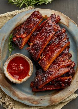 Keto food, spicy barbecue pork ribs. Slow cooking recipe. Pickled Roasted Pork Meat with red sauce. Asian Cuisine, Korean. Vertical, cloe up, macro