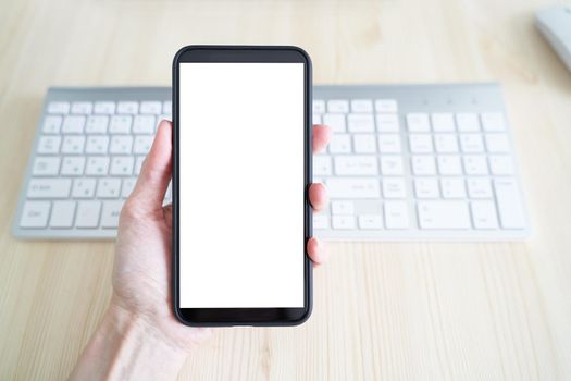 Unrecognizable person hold cell phone. View from behind, mockup with white phone display. White screen of mobile phone. Copy space, template