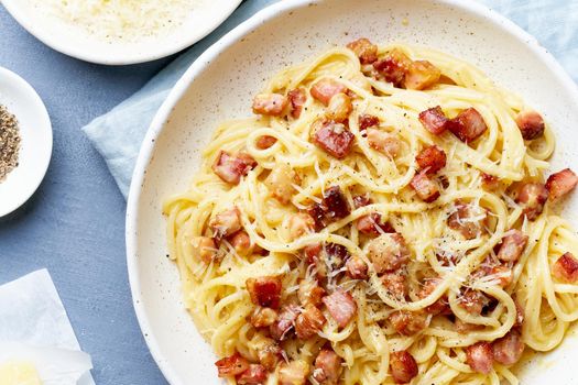 Carbonara pasta. Spaghetti with pancetta, egg, parmesan cheese and cream sauce. Traditional italian cuisine. Top view, part close up