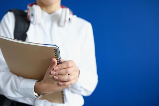 Close-up of student hold stack of books, prepare for exam in university or extracurricular. Woman with backpack, headset ready to learn. Knowledge concept