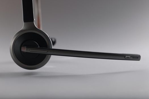 Close-up of headphones with microphone floating in air on grey background. Device to listen music and sing. Music, sound, technology, dj equipment concept