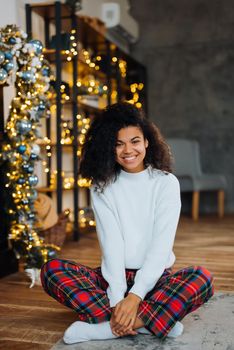 Beautiful young african american woman on the floor happy face smiling and looking at the camera. Positive person.