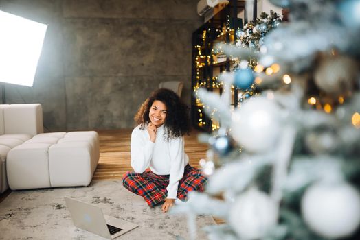 Beautiful young african american woman on the floor happy face smiling and looking at the camera. Positive person.