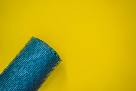 Everything for sports turquoise, blue shades on a yellow background. Yoga mat, sport shoes sportswear and bottle of water. Concept healthy lifestyle, sport and diet. Sport equipment. Copy space.