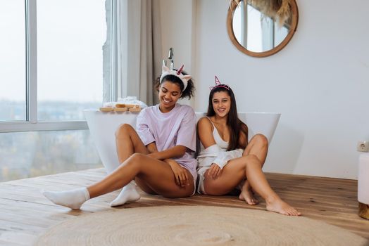 Two girls talking on the bathroom floor