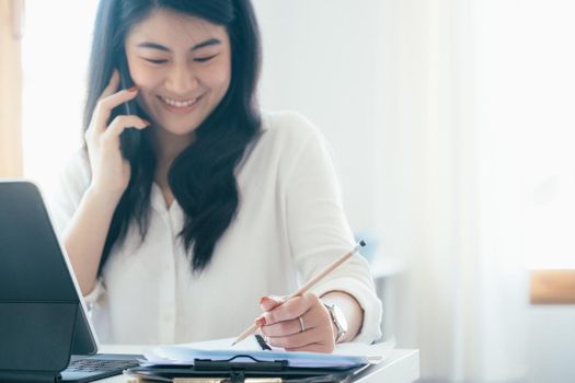 Young businesswoman talking and asking about information with customer on mobile phone.