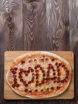 Father's day background. Pepperoni pizza with i love dad lettering on wooden tabletop. Father day concept, recipe and idea. Top view or flat-lay. Copy space for text. Vertical.