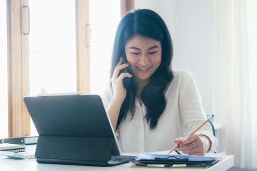 Young businesswoman talking and asking about information with customer on mobile phone.