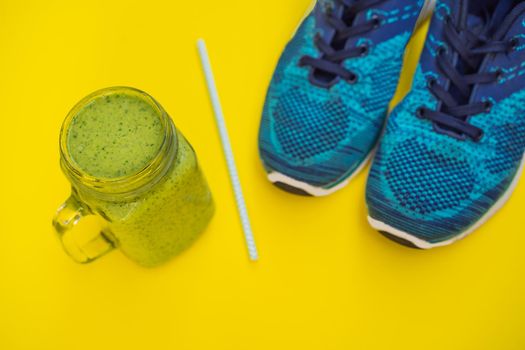 Everything for sports turquoise, blue shades on a yellow background and spinach smoothies. Yoga mat, sport shoes sportswear and bottle of water. Concept healthy lifestyle, sport and diet. Sport equipment. Copy space.