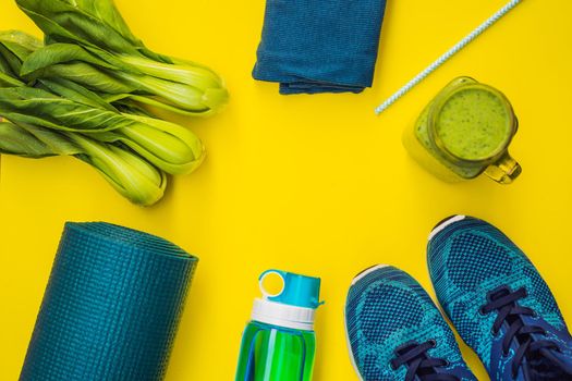 Everything for sports turquoise, blue shades on a yellow background and spinach smoothies. Yoga mat, sport shoes sportswear and bottle of water. Concept healthy lifestyle, sport and diet. Sport equipment. Copy space.