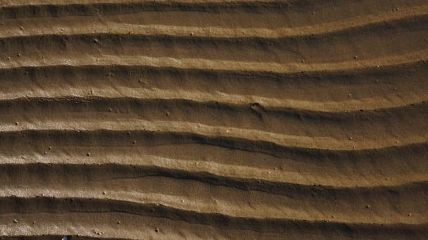 Stripes of fine sea sand on the coast. Natural background from the sand of the sea