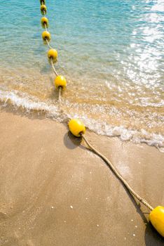 Floating buoy and rope dividing the area on the beach