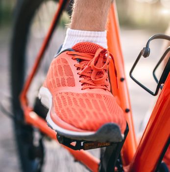 Close up view on leg in sneaker on bike pedal