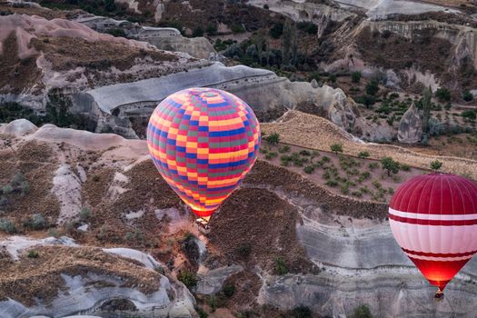 Top view of striped hot air balloon flying during festival in Cappadocia, Turkey