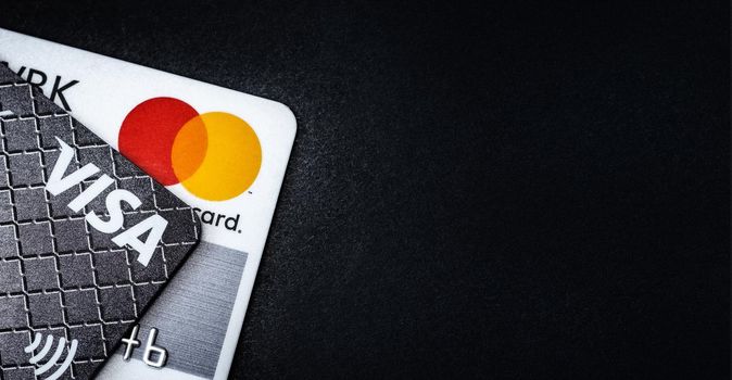 Kyiv, Ukraine - 03 June 2020: Credit cards Visa and Mastercard on black with copy space