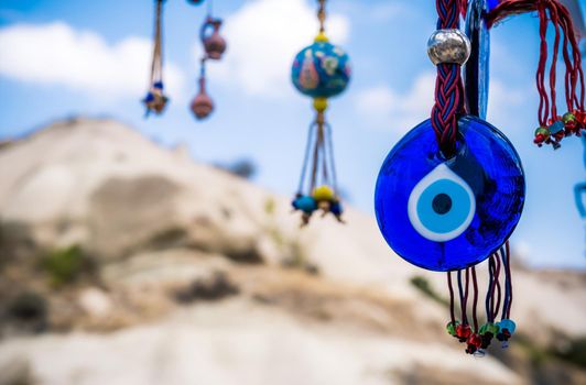 Evil eye amulets on foreground of sand mountain in Turkey