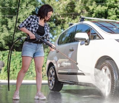 Girl with sprayer on self service car wash