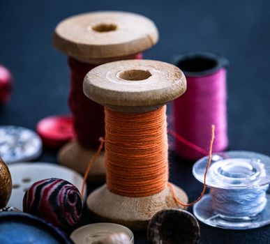 Bobbins of threads standing near buttons and beads