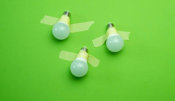 Three lamps lightbulb attached with tape on green background. Concept of creativity, innovation and brainstorm team ideas