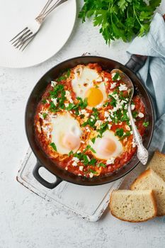 Shakshouka, eggs poached in sauce of tomatoes, olive oil, peppers, onion and garlic, Mediterranean cuisine. Keto meal, FODMAP recipe, low carb. Top view, vertical