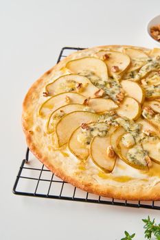 Part of fruit homemade sweet pear pizza with cheese and honey, Rustic Italian savory food with pastry dough, vertical