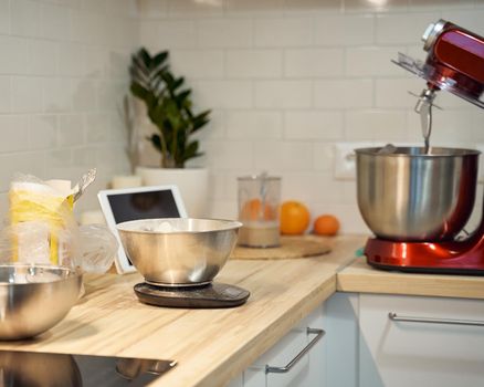 Cooking and baking food kitchen background at home, apartment, flour, scales, bowls, digital tablet with recipes on table