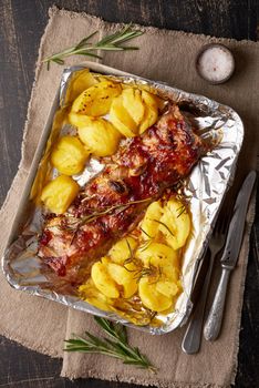 Spicy barbecue pork ribs and crushed smashed potatoes. Slow cooking recipe. Pickled Roasted Pork Meat on foil in tray, vertical