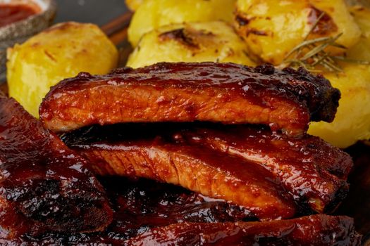 Spicy barbecue pork ribs and crushed smashed potatoes. Slow cooking recipe. Pickled Roasted Pork Meat with red sauce. American Cuisine
